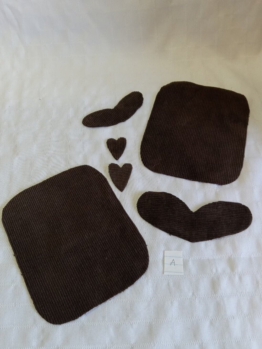 Two handmade elbow patches made of brown corduroy with heart-shaped accents